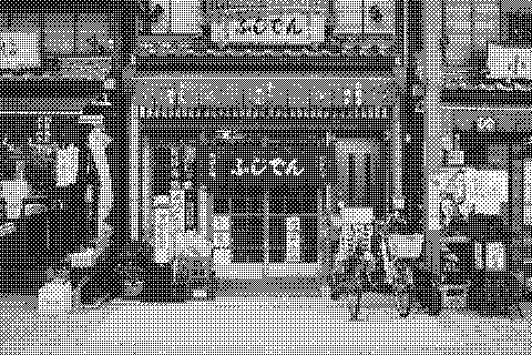 Bicycles are parked outside a small Japanese storefront with signs and windows. Dithered grayscale treatment.